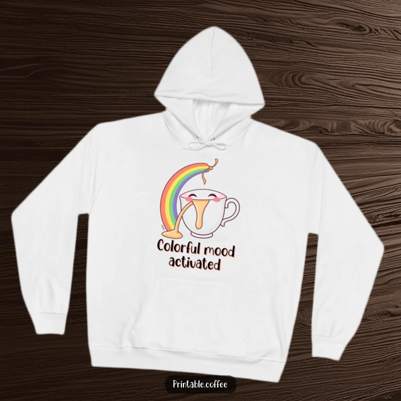 Funny teacup hoodie featuring a character smiling and pouring a vivid rainbow, designed for comfort and a cheerful mood.